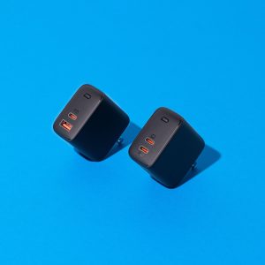 Two black gallium nitride chargers on a vibrant blue background.