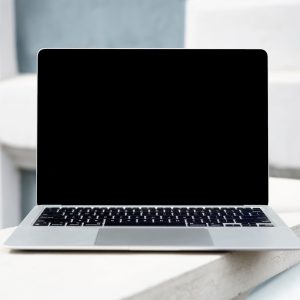 A sleek laptop with a blank screen on a white surface, perfect for digital mockups.